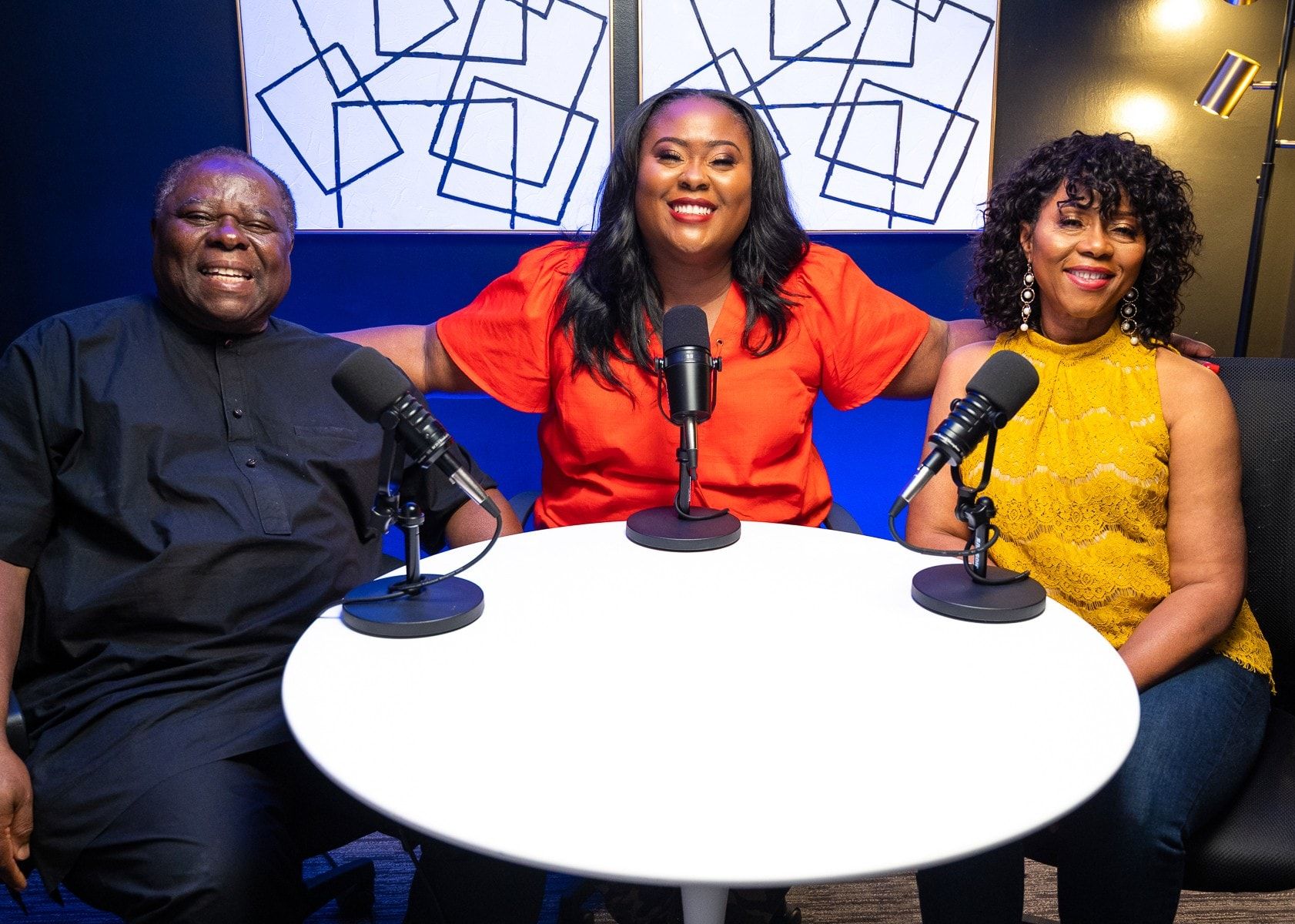 Ona recording a podcast with her parents at the studio table
