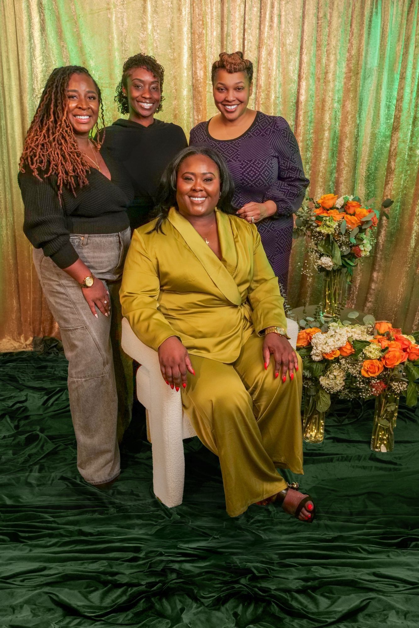 Ona seated in an olive suit with three of her close friends behind her