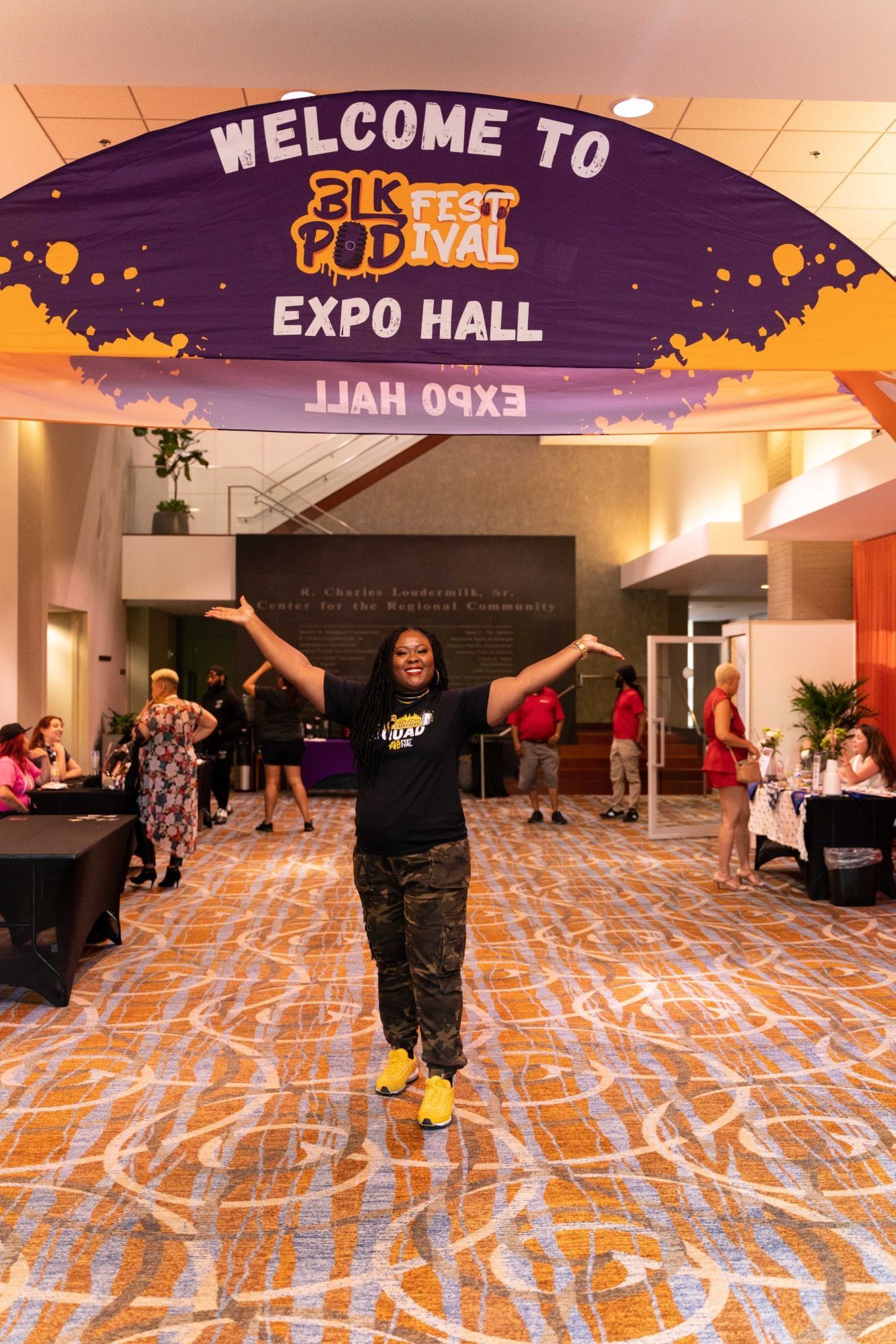 Ona with arms raised in the Blk Pod Festival expo hall